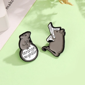 Cute cartoon mouse enamel pins featuring a mouse reading a newspaper and sitting on a base