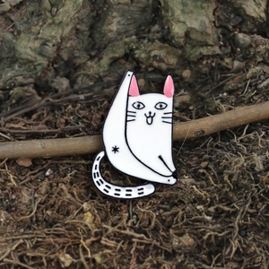 Pin's chat de yoga en émail blanc avec un corps triangulaire sur fond naturel rustique
