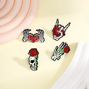 Gothic enamel pin set with white skull hands and red roses on light background