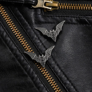Gothic black bat enamel brooch set displayed on a stylish black leather biker jacket