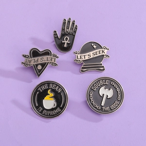 5-piece set of black enamel pins featuring coffee cup, crystal ball, heart, and hand motifs