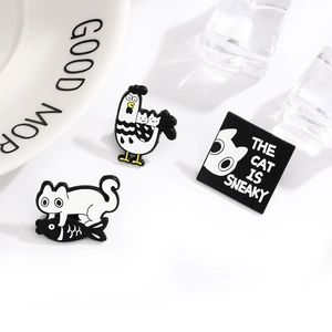 Three-piece enamel pin set featuring a white cat catching fish and a rooster carrying a kitten