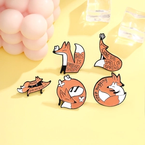 Lot de cinq broches en émail en forme de renard orange et blanc aux poses variées