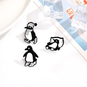 Lot de 3 broches pingouins en émail aux motifs de ski, de sommeil et de marche