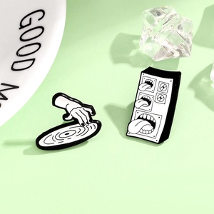 Set of two music themed enamel pins featuring a record player hand and surreal speaker with tongues
