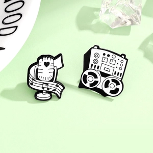Detail view of retro microphone and recorder enamel brooches with music themed designs