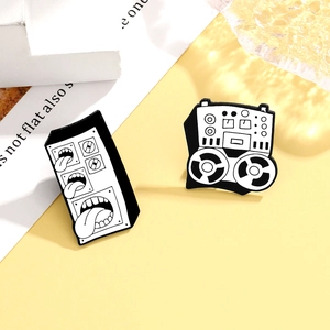 Cool music theme enamel pins featuring surreal speaker with tongue and retro tape recorder