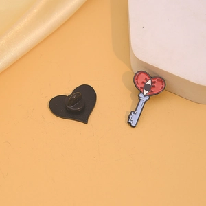 Creative enamel key and heart badge lapel pin with red heart eye design on silk background