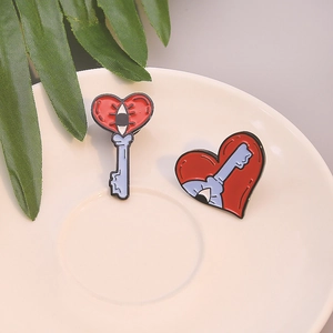 Creative red and blue enamel heart key and lock lapel pin set on a white ceramic plate