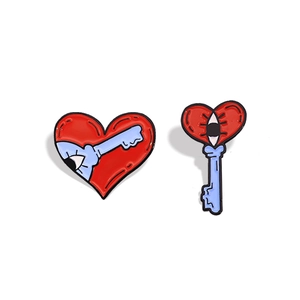 Surrealist heart and key enamel pin set with red, blue and eye elements on white background