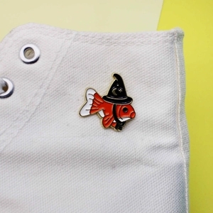 Broche en émail poisson rouge magicien avec chapeau de sorcier sur basket en toile