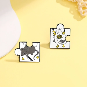 Detail of puzzle-shaped enamel pins featuring a mouse with dagger and chick with fries