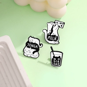 Detailed view of three enamel cat brooches with Jenga, Milk, and Ice Cat designs