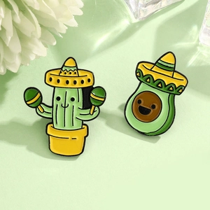 Cartoon cactus and avocado enamel pins with Mexican sombreros on a green background