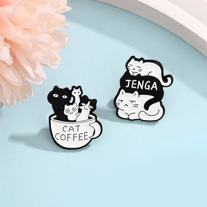 Close-up of cat coffee and cat jenga enamel pins on a fresh blue and floral background