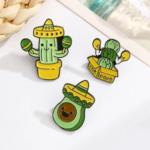 Detailed close-up of cartoon enamel pins featuring boxing cactus and avocado characters