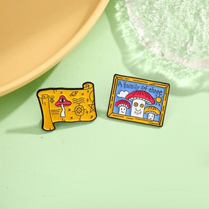 Detailed view of creative enamel pins featuring a yellow scroll and a mushroom family frame