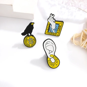 Macro shot of creative enamel lapel pins with unique heart gesture and crow designs