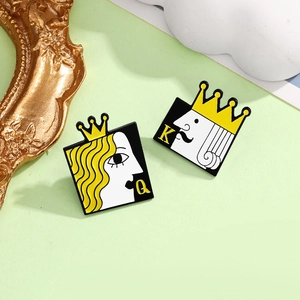 Detail view of enamel poker king and queen pins with crown elements on green art background