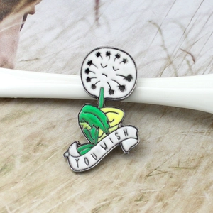 Macro detail of enamel dandelion brooch with YOU WISH white ribbon design