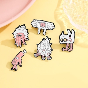 Surrealist cartoon enamel pin set with winged eye, skull, and shell designs on yellow base