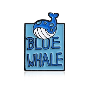 Cartoon blue whale enamel pin with blue whale lettering on a minimalist ocean tag