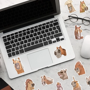 Autocollants de chevaux drôles décorant un ordinateur sur un bureau en marbre blanc chic