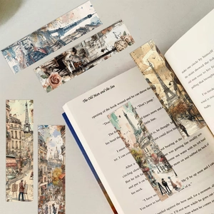 Καλλιτεχνικοί σελιδοδείκτες με παριζιάνικες σκηνές πάνω σε ένα ανοιχτό κλασικό βιβλίο