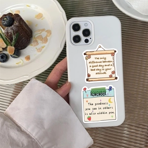 Détail d'une coque iPhone blanche avec autocollants de motivation et dessins de fraises
