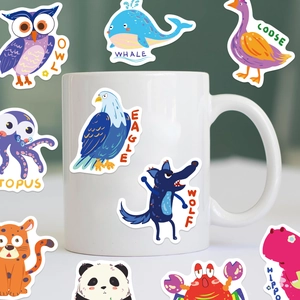 Gros plan d'autocollants animaux imperméables avec noms anglais sur un mug blanc