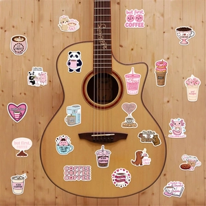 Coffee doodle stickers with cute animals shown decorating a folk acoustic guitar