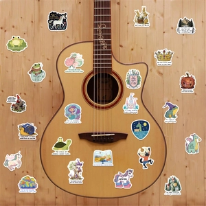 Close-up of waterproof fantasy cartoon stickers with inspirational quotes on guitar wood