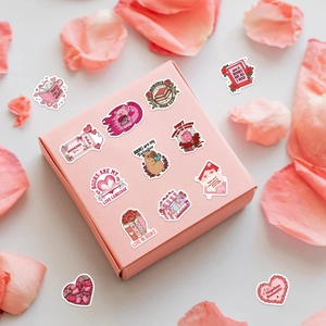 Detail showing romantic bookish stickers on gift box with pink rose petals around