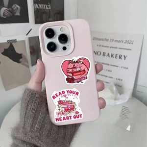 Dettaglio degli adesivi cartoon bookish su custodia iPhone rosa chiaro in mano