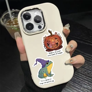 Close-up of a frog wizard and pumpkin sticker applied to a white phone case