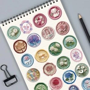 Macro view of 3D embossed floral seal stickers on a white notebook for journaling
