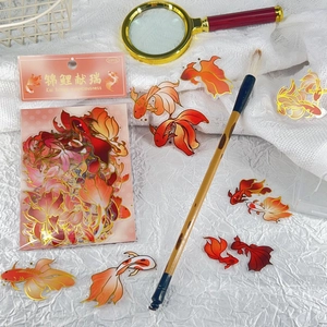 Close-up of koi fish stickers with gold foil details on decorative mesh and paper