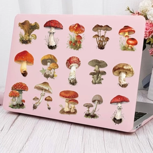 Pink laptop shell with retro botanical mushroom illustrations on a white wood desk