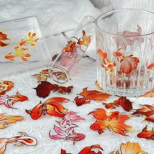 Detail of Chinese koi stickers with gold foil outlines on glass and plastic items