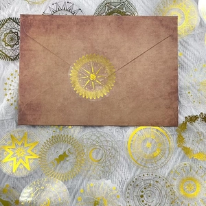 Dettaglio di adesivi celesti dorati usati come sigillo decorativo per buste