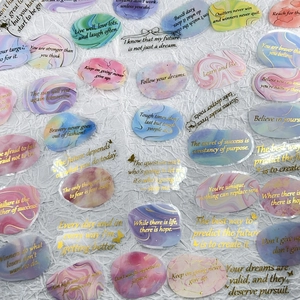 Close-up of marble pattern waterproof PET stickers with golden inspirational quotes
