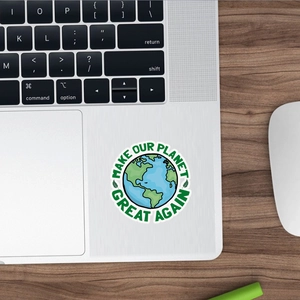 Close-up of a green earth sticker on a laptop with Make Our Planet Great Again text