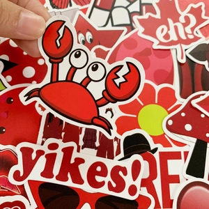 Detail of waterproof red cartoon stickers for luggage showing hand holding a crab decal