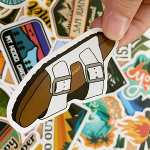 Detail of waterproof summer travel stickers featuring a white sandal die-cut design