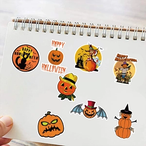 Close-up of Halloween pumpkin stickers with witch and black cat designs on a notebook