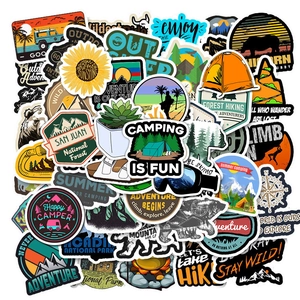 Close-up of waterproof camping stickers with tent and mountain designs for outdoor gear