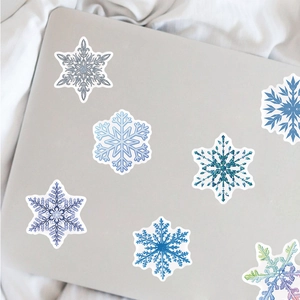50 wasserfeste Schneeflocken Aufkleber in Blau auf einem silbernen Laptop Deckel