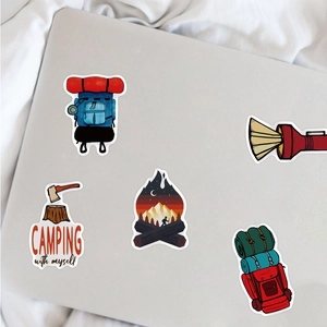 Close-up of 5 waterproof outdoor camping stickers on a silver laptop surface