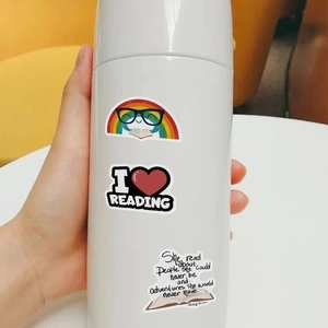 Gros plan d'un flacon isotherme blanc avec des autocollants de lecture pour enfants