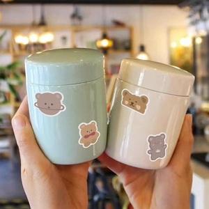 Detail view of cute cartoon bear stickers on portable green and white storage containers
